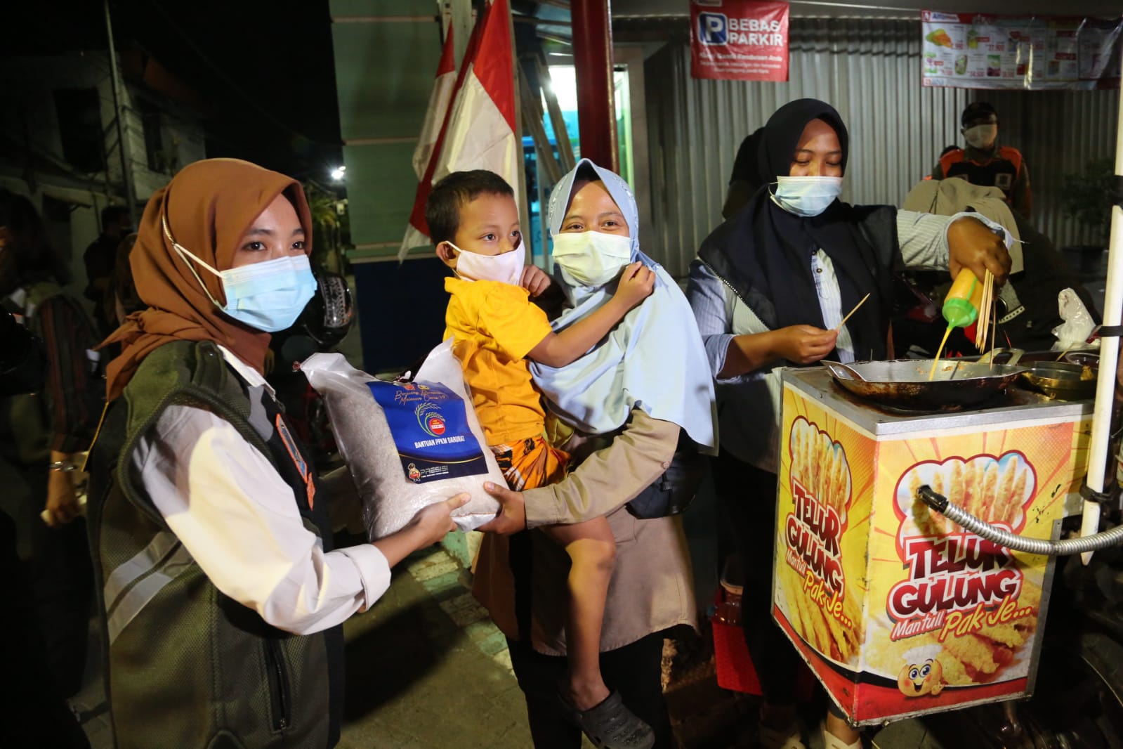 Aparat di Surabaya Edukasi Warga Tentang PPKM Darurat Sambil Bawa Sembako